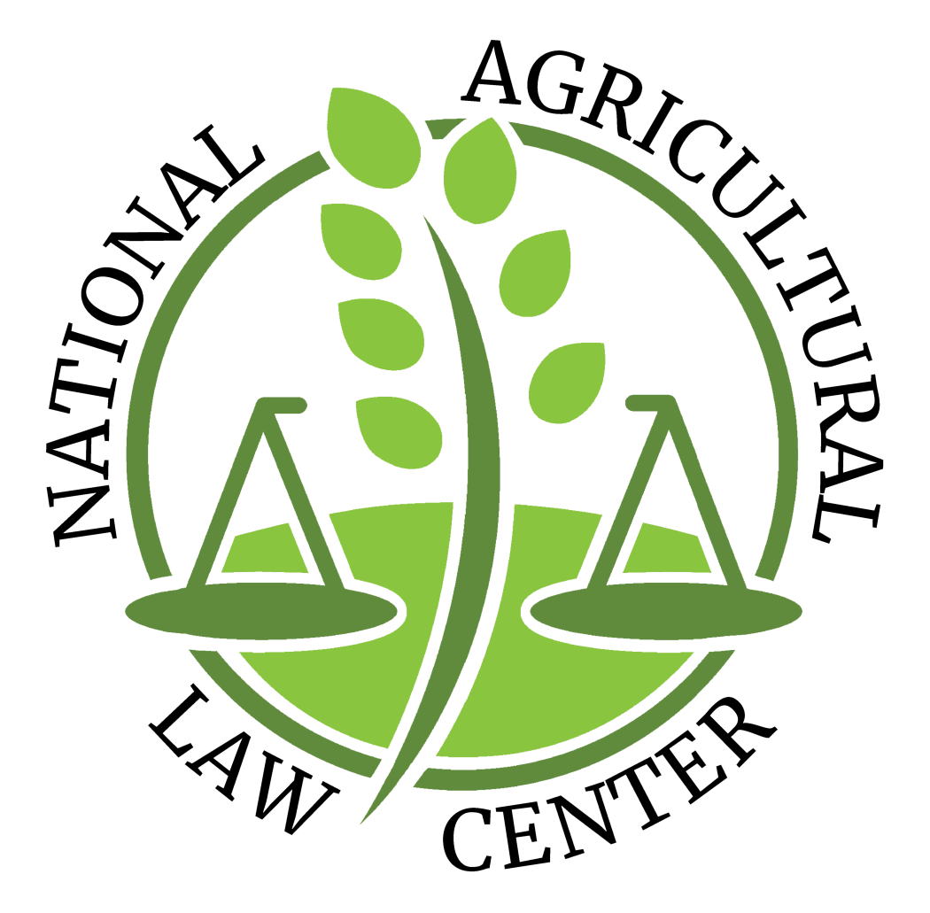 A circular logo in shades of green and white for the National Agricultural Law Center. Around the top edge, the dark green text reads "NATIONAL AGRICULTURAL," and around the bottom edge, it reads "LAW CENTER." Inside the circle, a stylized stalk of green wheat with leaves extends vertically through the center. On either side of the stalk sits a matching green scale of justice, both resting atop a curved green ground line.